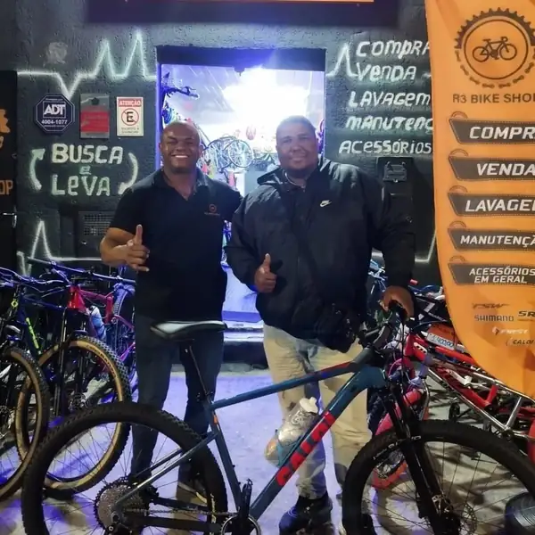 Clientes na loja da R3 Bike Shop com a bicicleta entregue