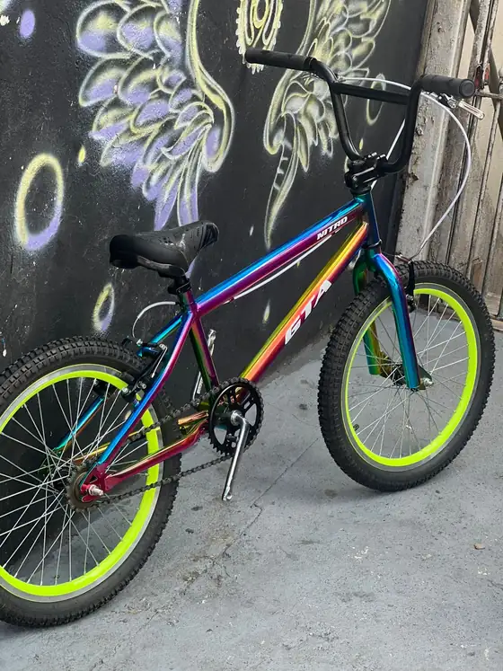 Bicicleta com aro verde limão encostada no muro