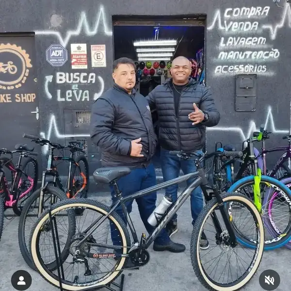 Dois clientes com a bicicleta nova em frente à loja