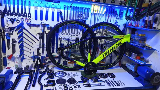 Bancada com bicicletas e peças sob a luz azul da loja