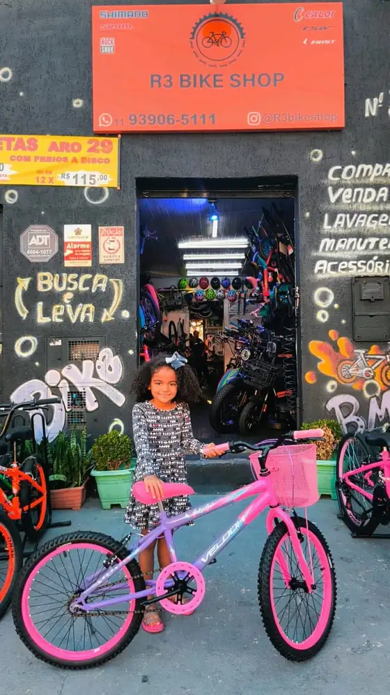 Cliente com bicicleta infantil rosa na porta da loja